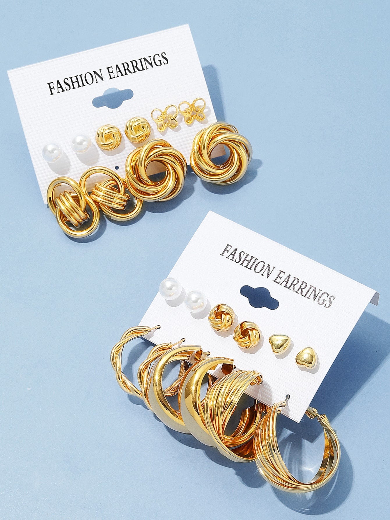 Set of gold and pearl fashion earrings featuring various styles including hoops, knots, hearts, and twists. Displayed on a card labeled 'FASHION EARRINGS' for easy selection and gifting.