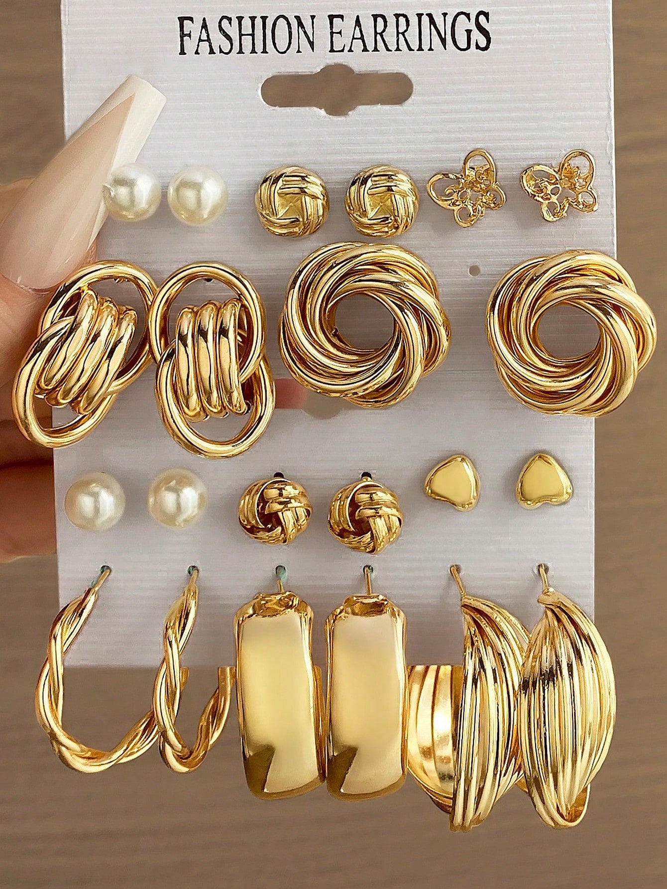 Set of gold and pearl fashion earrings featuring various styles including hoops, knots, hearts, and twists. Displayed on a card labeled 'FASHION EARRINGS' for easy selection and gifting.