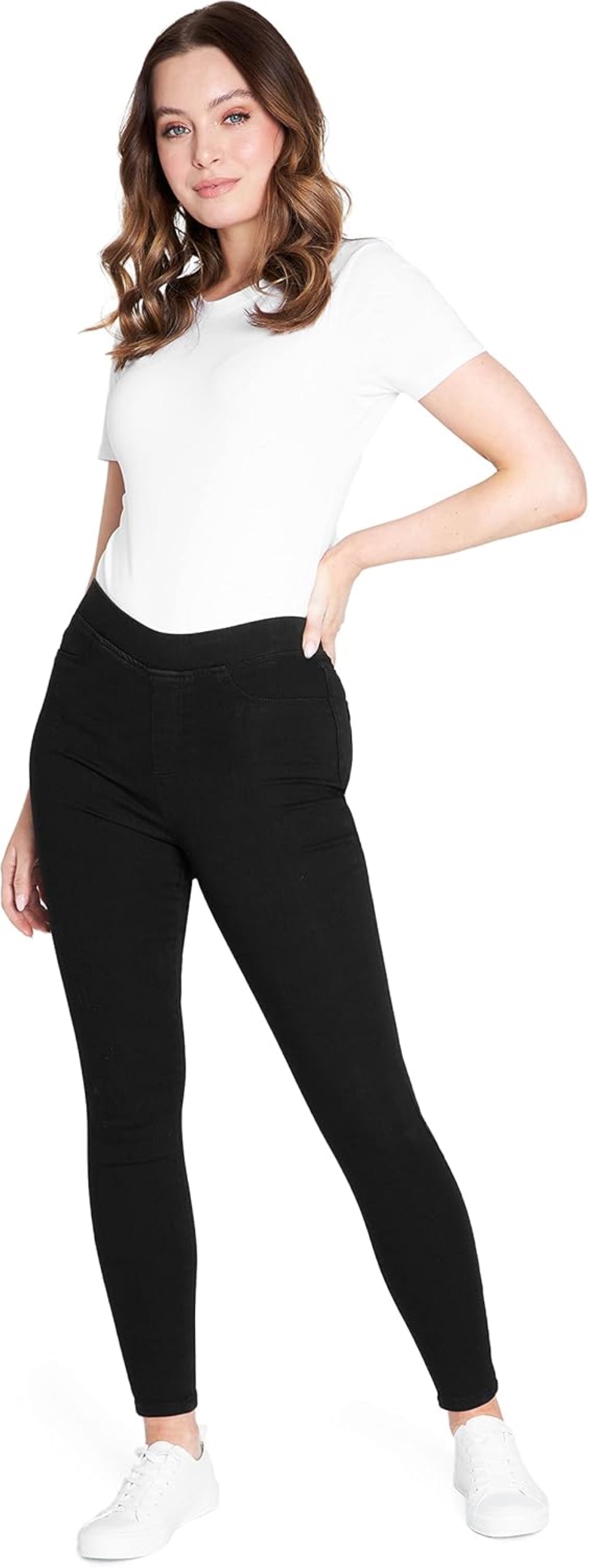 Woman wearing black stretchy leggings with functional back pockets, paired with a white short-sleeved shirt and white sneakers.