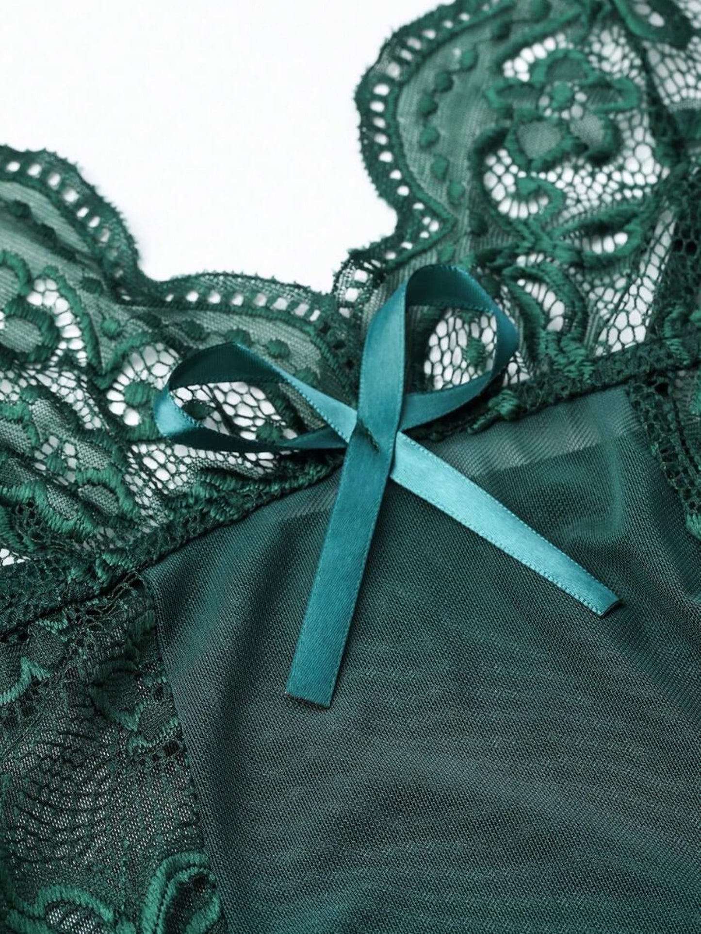 Close-up of green lace lingerie with bow detail.