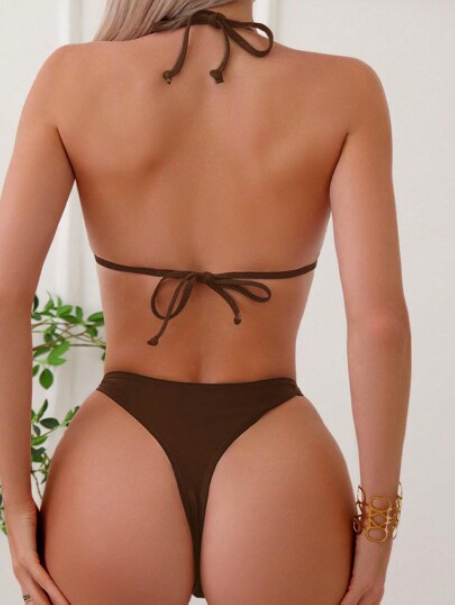 Brown bikini set worn by a woman on a white background