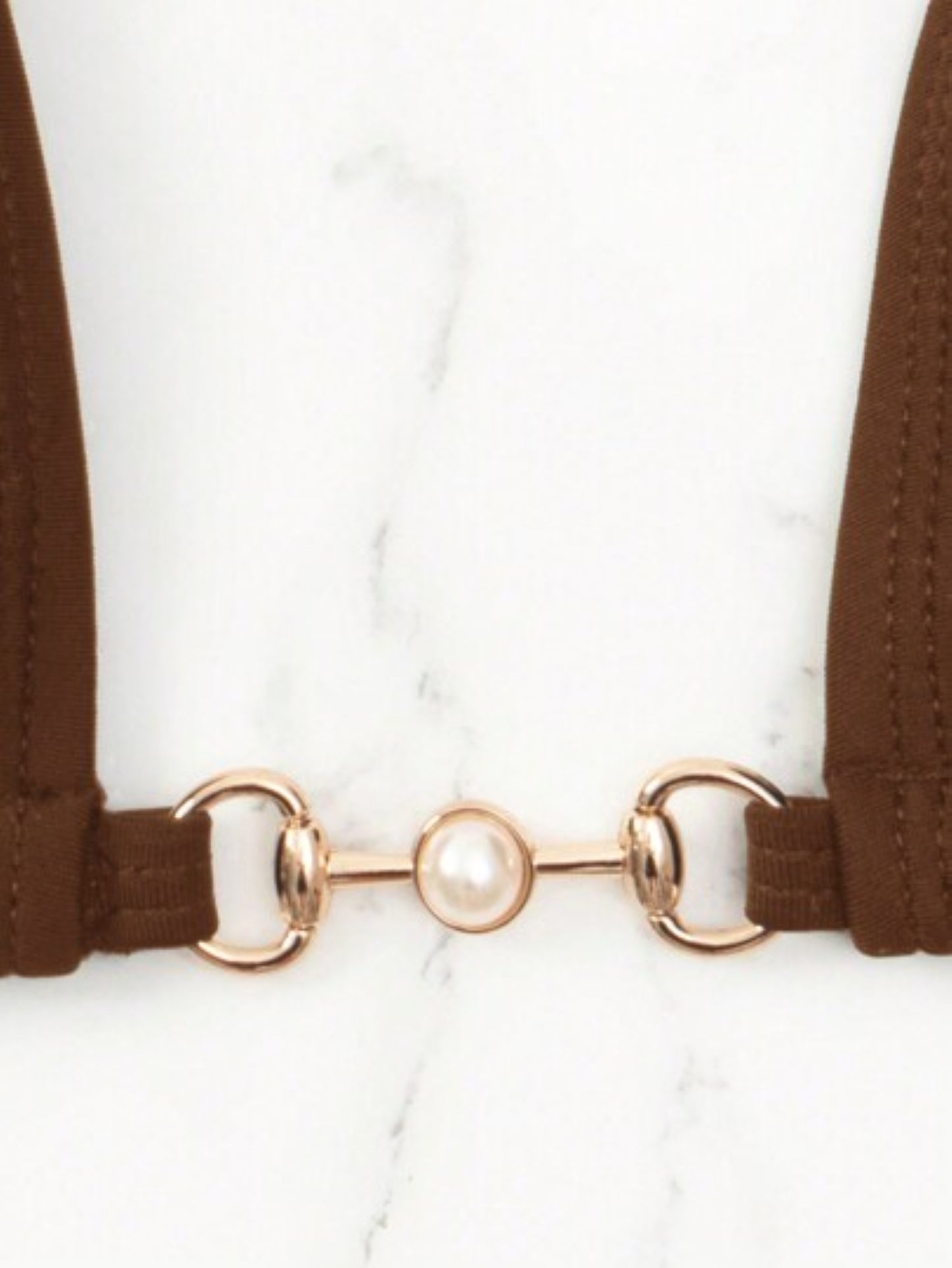 Brown suspenders with a gold clasp on a white background