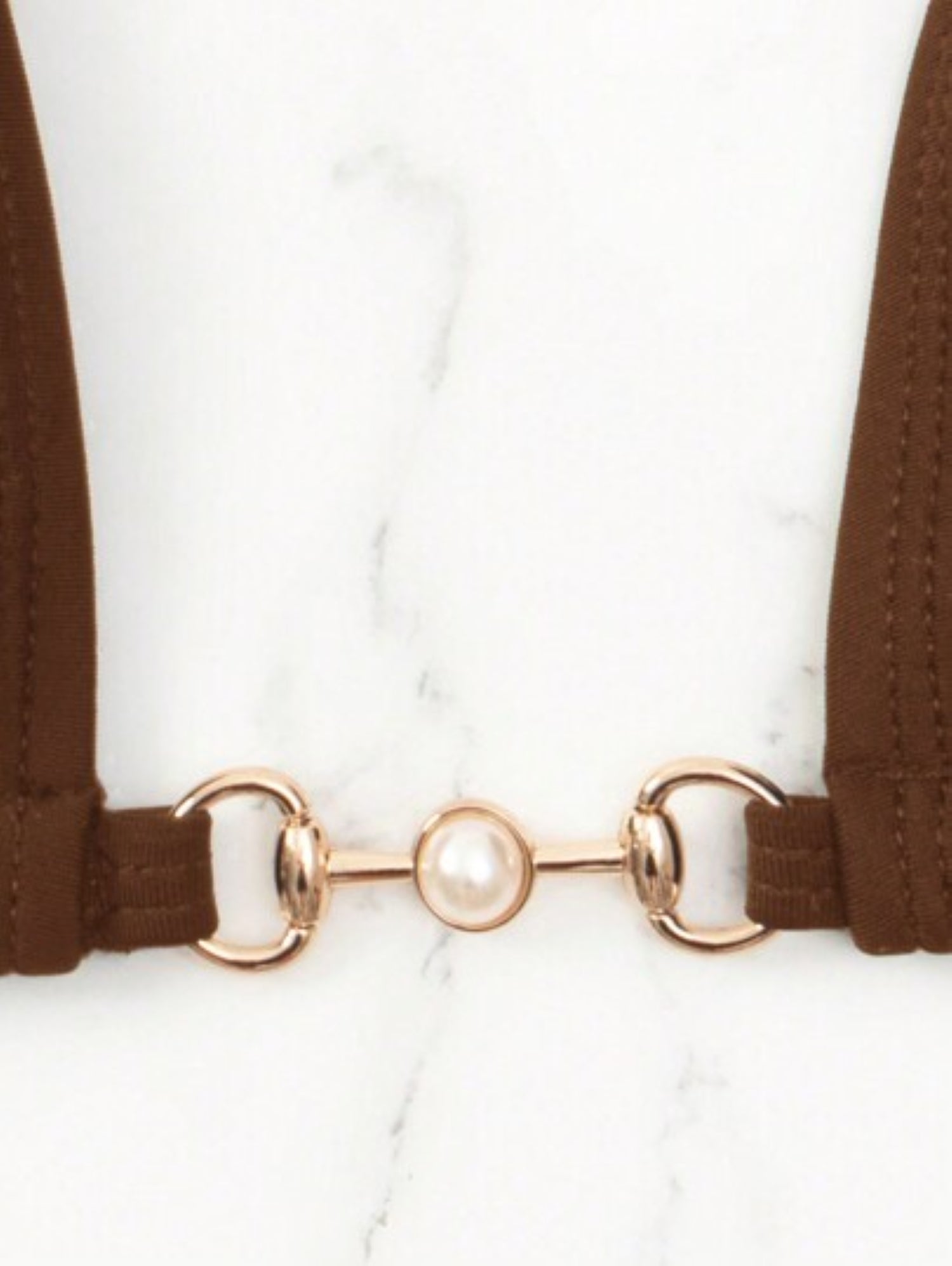 Brown suspenders with a gold clasp on a white background