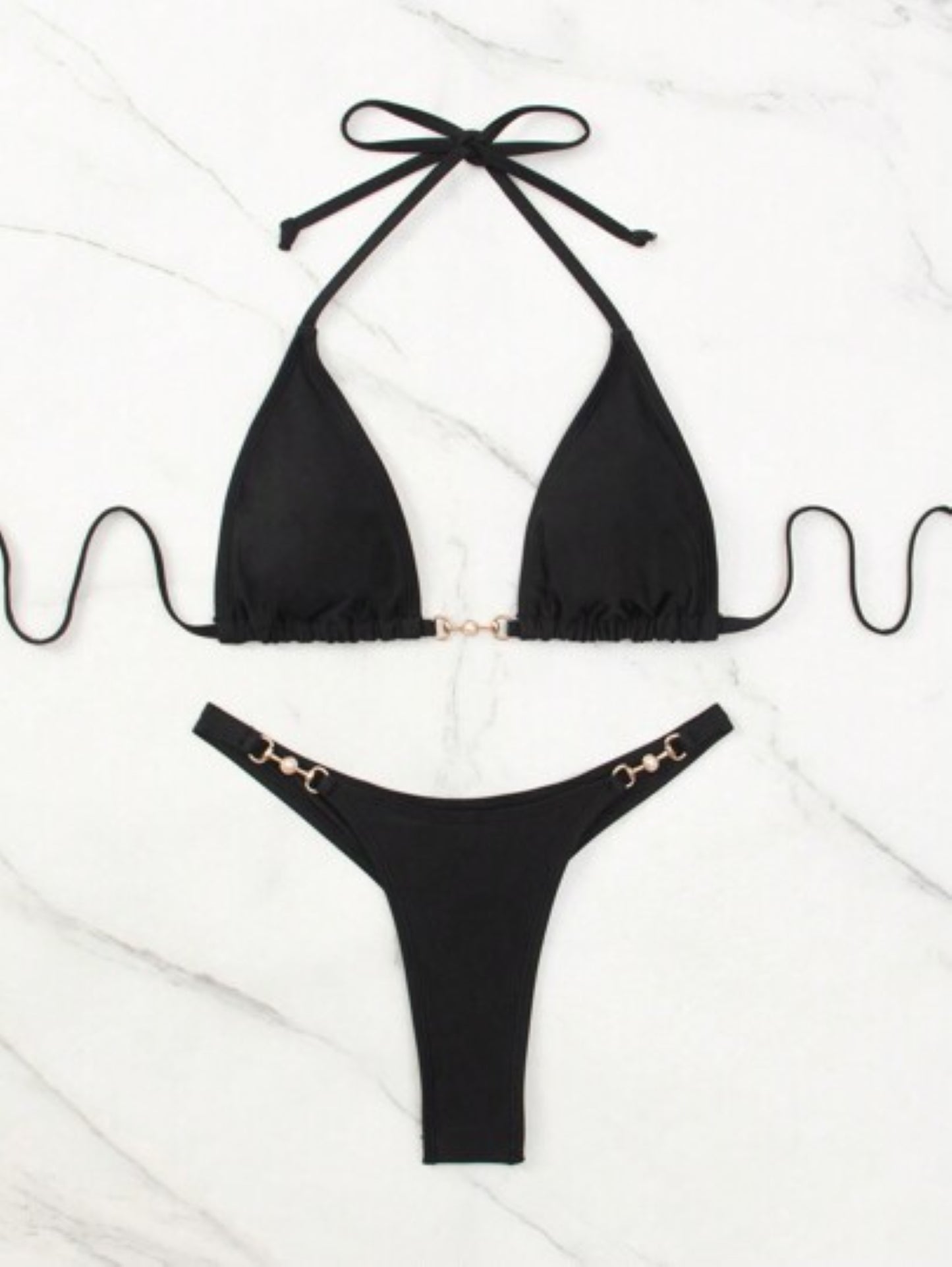 Black bikini set with gold accents on a white background