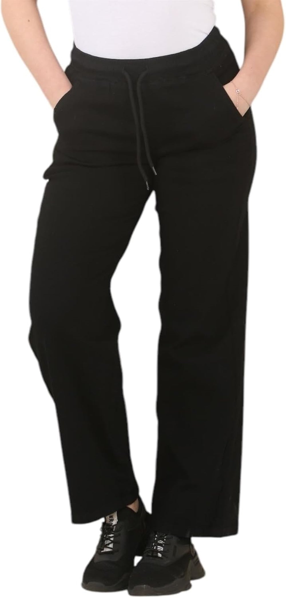Black wide-leg pants with elastic waistband, pockets, and drawstring, paired with a white tank top and black sneakers.
