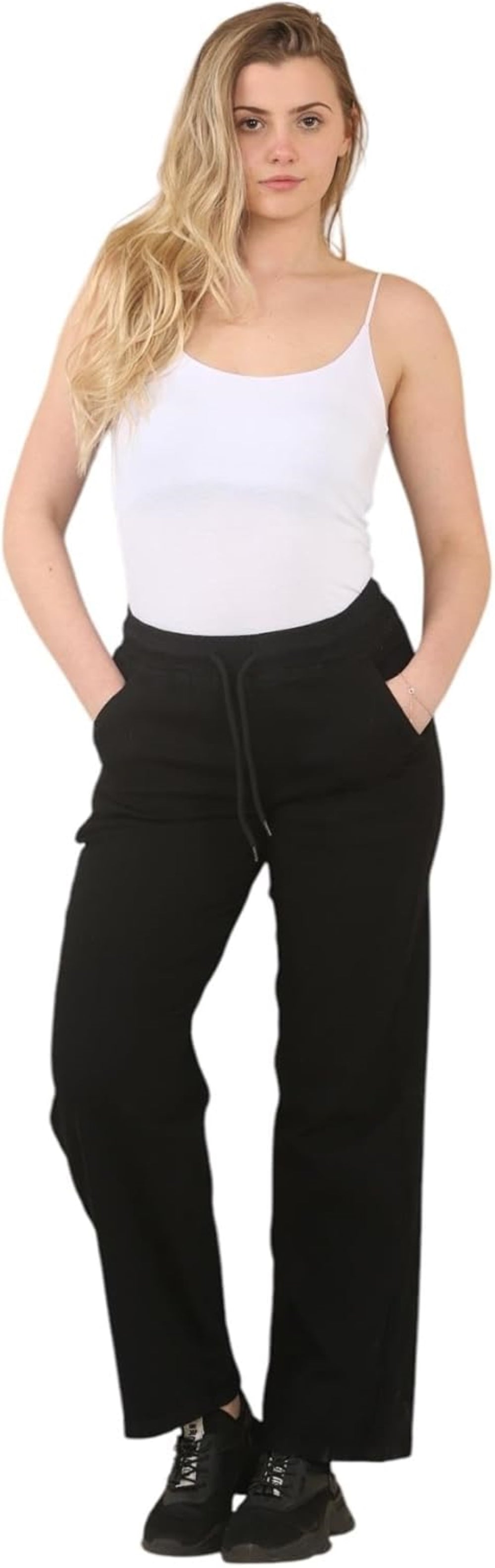 Black wide-leg pants with elastic waistband and pockets, paired with a white tank top and black sneakers