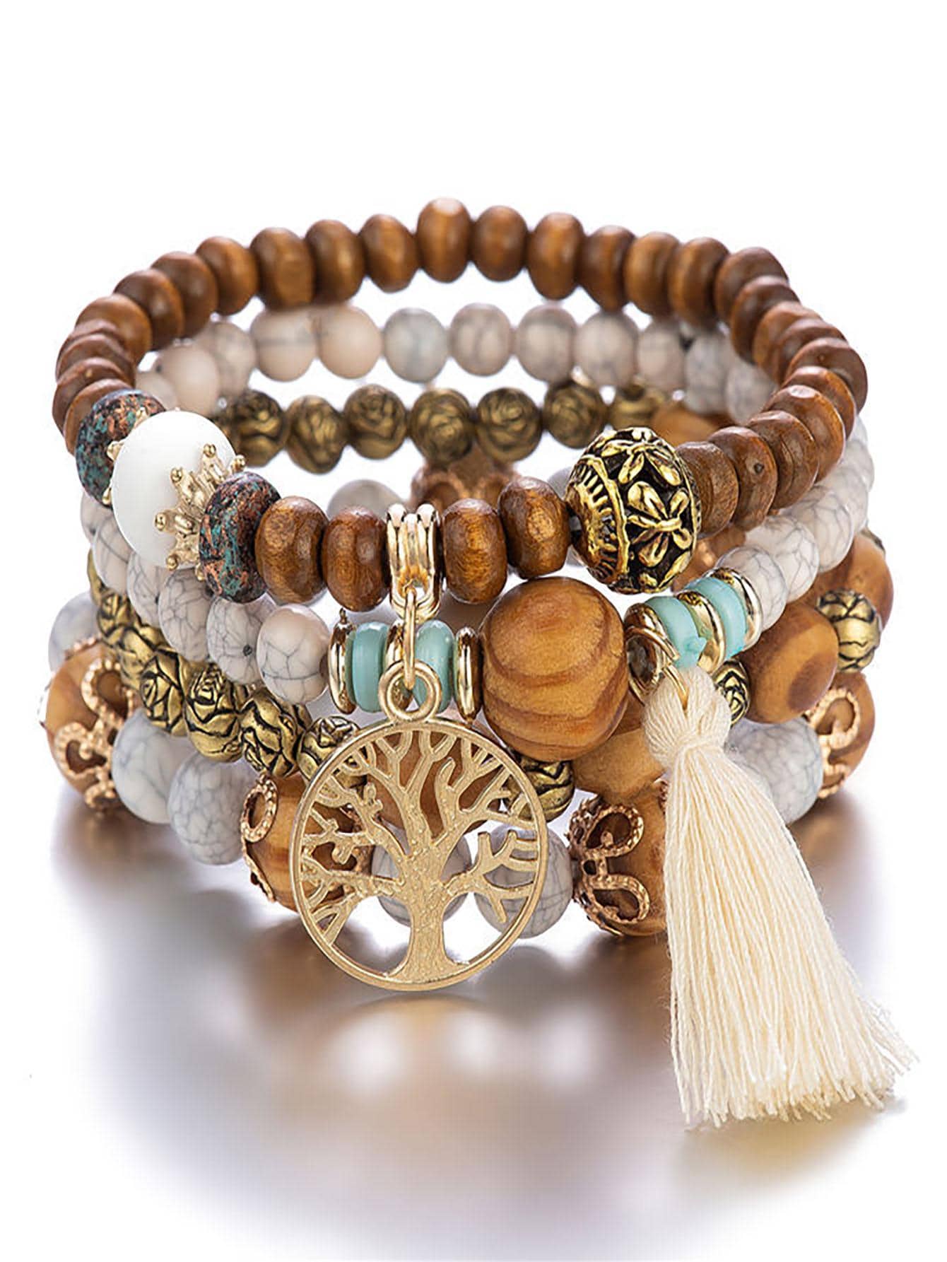 Stack of multilayered bracelets with wooden beads, turquoise beads, and gold accents. Features a gold tree of life pendant and a white tassel. Bohemian style displayed on a white background.