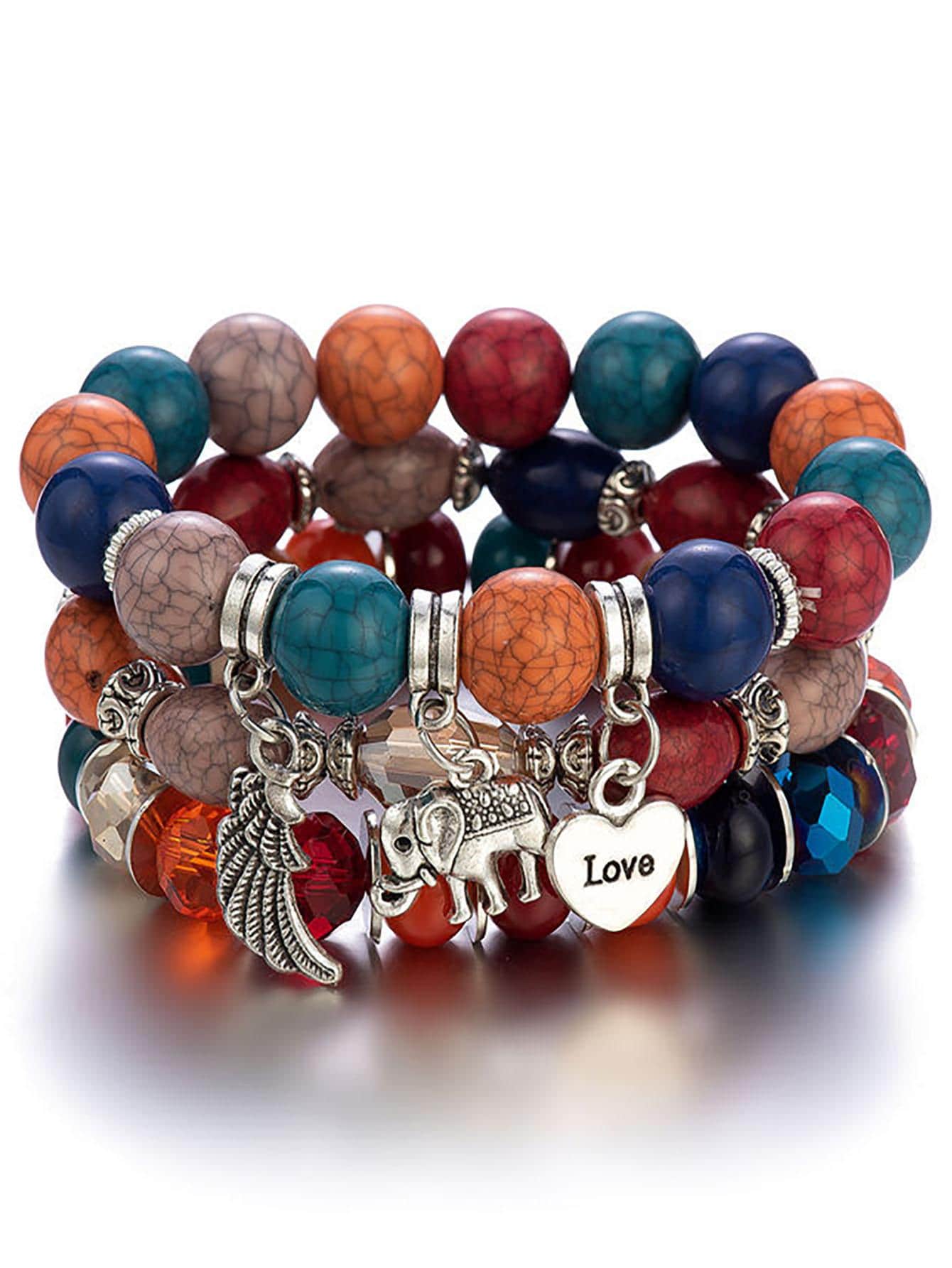 Stack of multicolored beaded bracelets with silver charms including a wing, elephant, and heart pendant with 'Love' text. Layered design with elastic bands for comfortable wear.