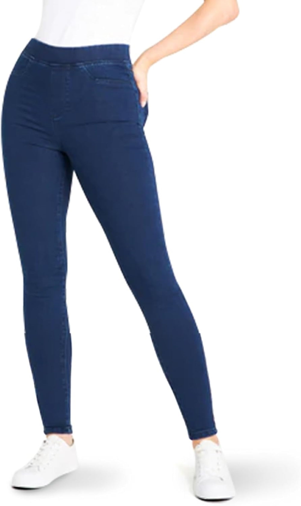 Woman wearing dark blue skinny jeans with a white short-sleeved t-shirt and white sneakers.