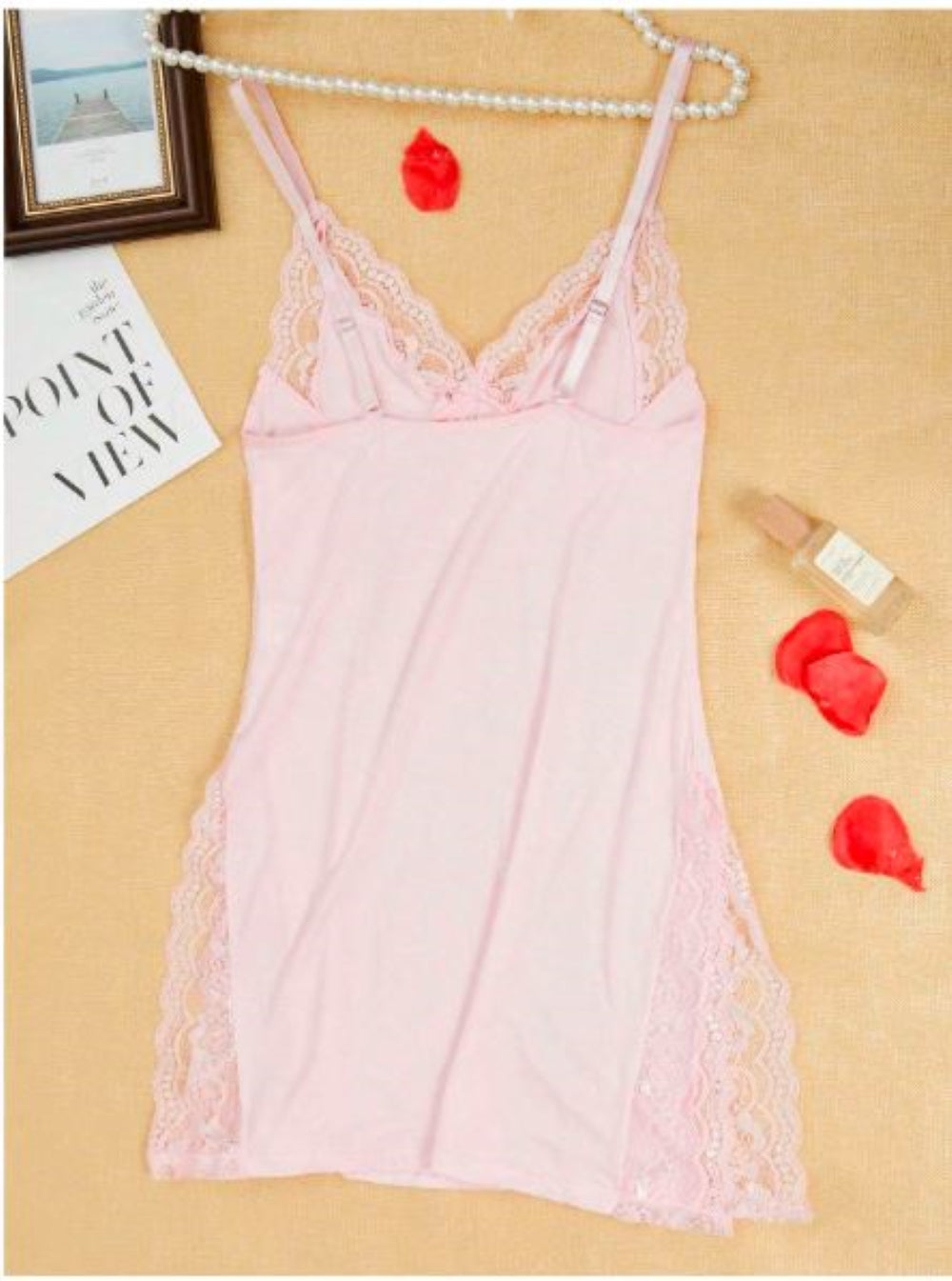 Pink  chemise with lace trim and thin straps. The garment is displayed on a hanger against a peach background, accompanied by a card with "V-Day" written on it and a few white tulips.